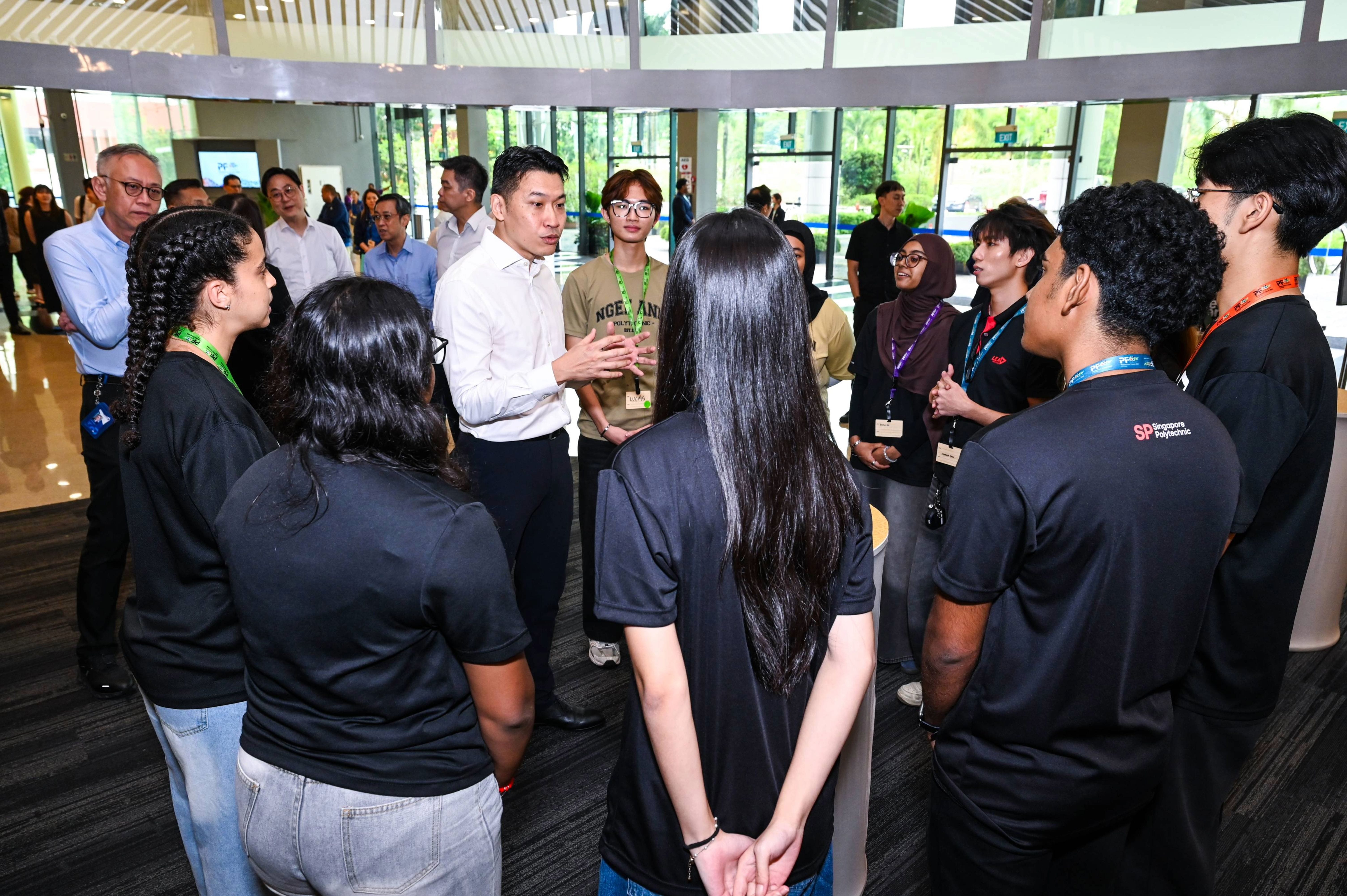 Selected student delegates engaging Minister David Neo in a conversation following the Opening Ceremony.